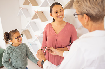 Image showing Happy mother, child and and optometrist with glasses eye exam for eyesight, eyes wellness and healthy vision. Girl with mother, eyecare store and shopping eyewear, spectacles or prescription lenses