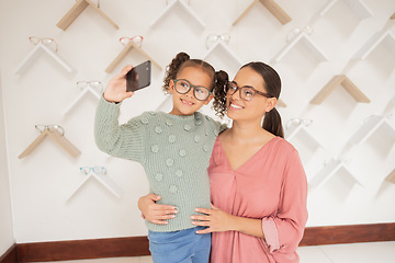 Image showing Selfie, phone and family with vision glasses at retail shop for wellness, eye care and health. Mother, child and smile for smartphone social media photograph together in expert optometry shop.