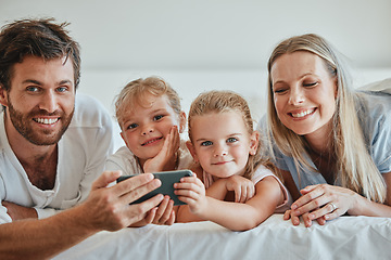 Image showing Happy, family and relax with phone on the bed in fun entertainment streaming together at home. Mother, father and children relaxing in the bedroom with smile for online shows on smartphone indoors