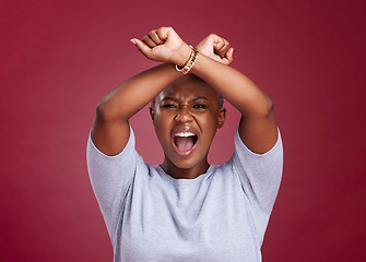 Image showing Black woman, shouting and protest to stop racism or discrimination against a red studio background. Angry African American female voice with arms crossed on strike or fight for human rights on mockup