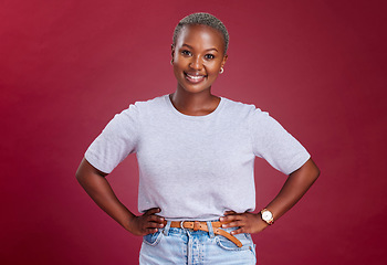 Image showing Young, african woman and hands on hips in studio for beauty, fashion and style with happiness. Happy black woman, portrait pose or smile face against red background for cosmetics, makeup or glow skin