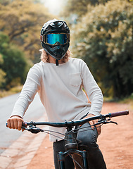 Image showing Mountain bike, helmet and fitness with a man athlete sitting on his bicycle while outdoor in nature for a ride. Road, cycling and sport with a male rider training outside for exercise or workout