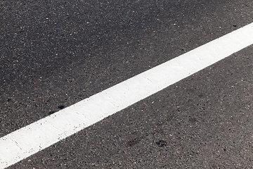 Image showing close-up of an asphalt road with white road markings