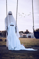 Image showing Halloween, ghost costumes and sunglasses in the park for scary family holiday celebration together. Father or mother with child playing spooky dress up wearing sheets to terrorize the neighborhood