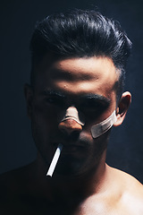 Image showing Cigarette, boxer and man with fighting injury, wound and bandaid after fight, violence or accident in a dark studio. Portrait of fighter, shadow or gangster smoking after MMA match or crime