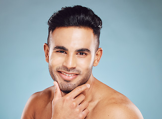 Image showing Portrait, Indian man and skincare for wellness, smile and happy with blue studio background. Male, confident or natural beauty for cosmetics, luxury or happiness for organic facial or pride with fun