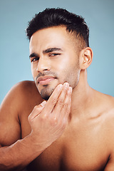 Image showing Skincare, portrait and man in blue studio thinking of facial hair wellness, health and cosmetics beauty glow. Young, sexy and face model with beard growth idea for skin care, self love or dermatology