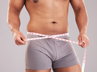 Image showing Fitness, body and tape measure to lose weight from diet, exercise and sports training in studio for goals, motivation and inspiration. Model on grey background for weightloss progress and results