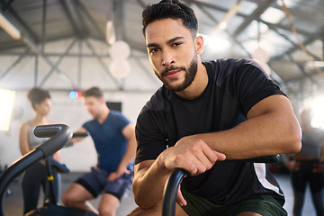 Image showing Gym, portrait and man exercise on spinning bike for health, training and fitness goal at a sports center. Personal trainer, coach and mexican man with a vision for wellness, heart health and workout