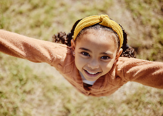 Image showing Top view, child or girl in fun game pov in nature park, garden environment or sustainability grass field in summer break. Portrait, smile or happy youth kid playing or jumping or in energy activity