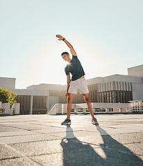 Image showing Fitness, man and stretching arm in the city for warm up exercise, training or cardio workout in the outdoors. Active male in morning stretch for sports activity, performance or exercising in the town