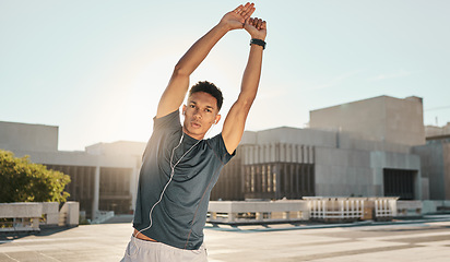 Image showing Fitness, earphones and man stretching in city while streaming music, radio or podcast. Health, wellness or male from India warm up while listening to audio, song or sound track in town in the morning