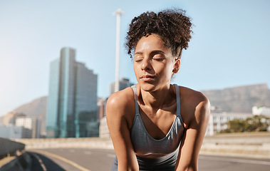 Image showing Fitness, tired woman and runner on a break in the city after running exercise, training or cardio workout in the outdoors. Exhausted female taking a breath from exercising or run in a urban town