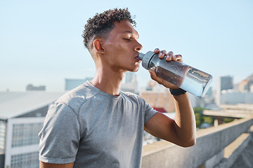 Image showing Fitness, exercise and man drinking water in city after running, training or cardio workout. Health, wellness and hydration of sports male from India resting or on break after marathon or sprinting.