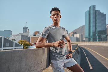 Image showing Runner, fitness and water with a sports man taking a break from his workout or training in the city. Wellness, running and health with a male athlete resting during cardio or endurance exercise