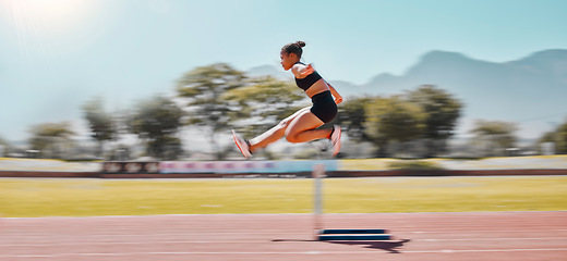 Image showing Athlete, sports and woman jump hurdle for track and field event for obstacle race or course for running, exercise and training for marathon. Female outdoor for sport, workout and energy at a stadium