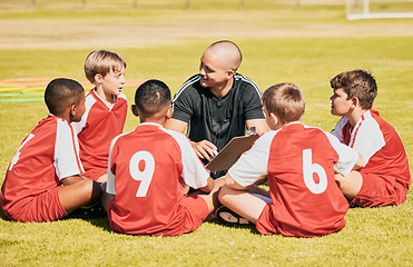 Image showing kids, soccer and team coach planning training with clipboard on soccer field for sport competitiion together. Athlete children, teamwork and sit on grass before football match or workout outdoors