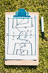 Image showing Sports, soccer field and clipboard planning a strategy for a group mission, target or tactics for goals. Solutions, teamwork and coach drawing winning tactics or ideas on grass in a football stadium