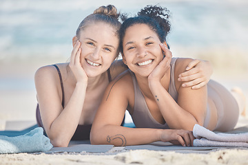 Image showing Friends, beach and diversity with a black woman and happy friend lying on the sand by the sea or ocean in nature. Face, smile and summer with a female and friend by the water to relax on vacation