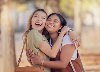 Image showing Women, friends and happy hug in outdoor sunshine with embrace, love and smile in summer for vacation. Diversity, asian woman and black woman with happiness in nature, park and together in Jakarta