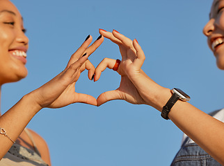 Image showing Heart, love and friends with a sign of their support, trust and happy against a blue sky. Nature, care and women with emoji hands for travel natural environment and wellness in summer together