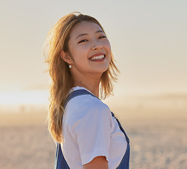 Image showing Happy, asian woman and portrait smile on the beach for fun, travel or vacation trip in the outdoors. Japanese female smiling for joyful holiday walk or traveling in happiness by the sandy ocean coast