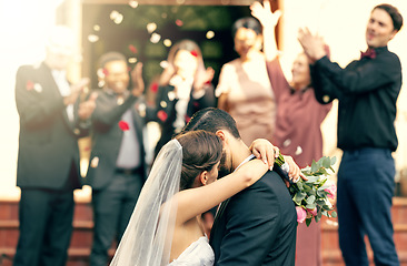 Image showing Bride, groom and kiss in wedding celebration with applause from family, friends or guests at the church. Man and woman couple kissing, hugging or embracing marriage in romance for happy relationship