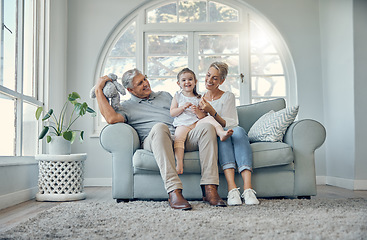 Image showing Happy, relax and grandparents with a child on sofa in the living room at family home. Happiness, grandmother, grandfather and girl kid sitting on couch together while playing, bonding and relaxing.