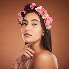 Image showing Flower, crown and woman with beauty, makeup and portrait against a brown studio background. Spring, cosmetics and face of a young model with flowers for summer, harmony and accessory in hair