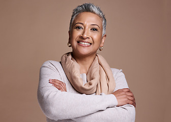 Image showing Face, fashion and style with a senior woman in studio on a brown background to model contemporary clothes. Portrait, fashionable and stylish with a mature female posing to promote a clothing brand