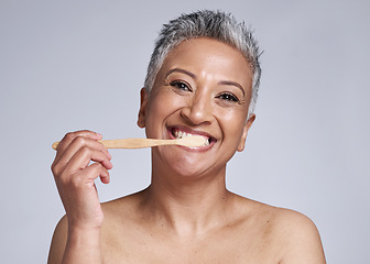 Image showing Mature woman, toothbrush and brushing teeth on studio background, morning grooming routine or healthcare wellness. Portrait, smile or beauty model in dental care cleaning or happy hygiene maintenance