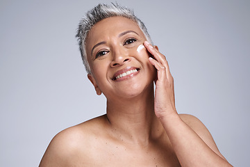Image showing Face, skincare and beauty with a mature woman using moisturizer for antiaging treatment in studio on a gray background. Wellness, facial and portrait with a senior female inside for dermatology care