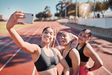Image showing Fitness, selfie and athletes training on a track for a marathon for health, wellness and exercise. Sports, smile and happy friends taking a picture with a smartphone after a workout on a field.
