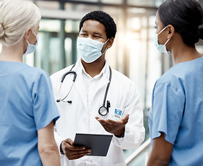 Image showing Face mask, covid and team of doctors with tablet doing research or checking test results in clinic. Medical, hospital and group of healthcare workers in collaboration on mobile device during pandemic