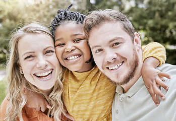 Image showing Happy, interracial family and smile portrait of a mother, girl and father with bonding in nature. Diversity, love and adoption care of a mom, kid and man hug together with youth happiness outdoor