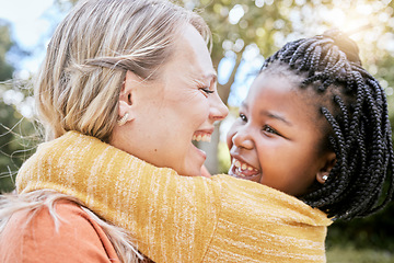 Image showing Happy family, love and interracial mother and girl hug at a park, happy and relax while bonding, laughing and having fun in nature. Adoption, foster and woman with black child, hug and joy