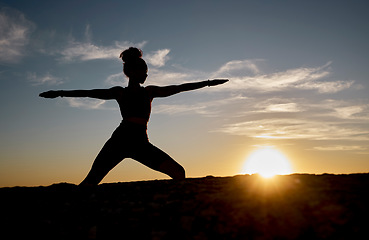 Image showing Silhouette, yoga and sunset with woman on rock for training, fitness and zen wellness. Spiritual, faith and health with pilates girl workout with warrior pose in nature for relax, peace and balance