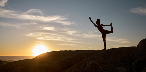 Image showing Woman, silhouette or yoga on sunset beach rocks in relax fitness, training and exercise for mental health, body mobility or wellness. Yogi, pilates or workout at sunrise for zen stretching by ocean