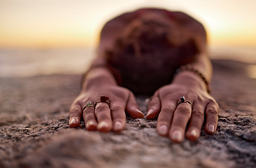 Image showing Fitness, woman meditation or yoga hands on sand floor stretching at the beach, ocean or sea with sunset in background for wellness, exercise or zen. Girl, health for chakra focus, mindset or pilates