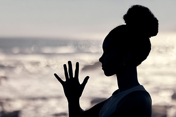 Image showing Meditation, wellness and silhouette of woman at a beach doing yoga, exercise and workout. Fitness, mindfulness and shadow of head and hands of female by ocean to meditate, calm and relax in training