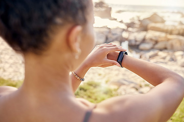 Image showing Fitness, smartwatch and time, cardio and woman at beach for exercise and sport technology for training outdoor. Workout, nature and athlete check watch, sports motivation and endurance on the coast.