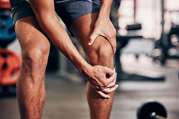 Image showing Fitness, exercise and man with knee pain in gym holding leg after injury, accident and muscle pain. Healthcare, sports and male athlete with sore joint, hurt after exercising, workout and training