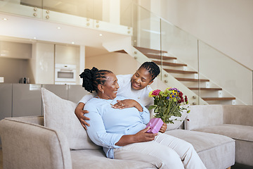 Image showing Mothers day, black woman and surprise flowers on sofa for present, box or gift to mom in living room. Woman, bouquet or senior mama on couch with wow, happy or smile for love, celebration or birthday