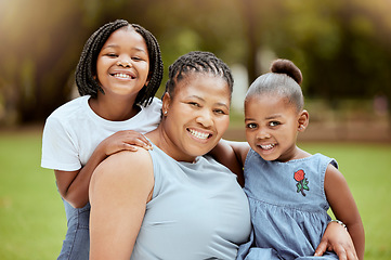 Image showing Black woman, children and nature park of a family together with a smile and hug bonding outdoor. Portrait of mother, garden and girl siblings with happiness, love and care feeling positive in summer