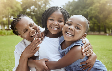 Image showing Love, black family hug and grandmother with children enjoy outdoor quality time together, peace or nature park freedom. Fun kids, bond and portrait of excited sisters play with grandma on grass field