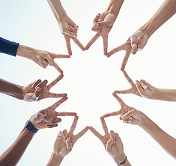 Image showing Diversity, teamwork and hands with star shape for community, team building or support with a sky background. Collaboration, peace and bottom view of group of people with fingers in unity for bonding.