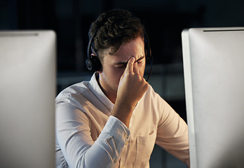 Image showing Call center, telemarketing and man with headache and stress working overtime at night. Burnout, tired and frustrated male consultant sitting in office for crm, customer support and customer service