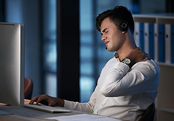 Image showing Call center, neck pain and business man at night with burnout, stress and fatigue at office desktop computer consulting. Telemarketing or salesman consultant with shoulder pain or health risk problem