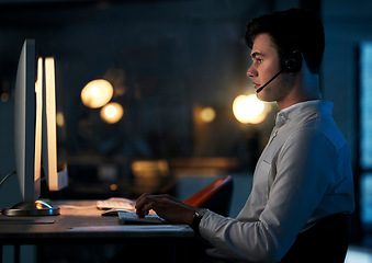 Image showing Call center, night office and employee typing, working late shift or overtime for commission. Crm, contact us and telemarketing, sales agent or support worker in dark office consulting on computer.