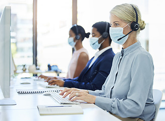 Image showing Covid, call center and customer service with a business woman a work in a sales or telemarketing office. Corona, crm and contact us with a female consultant in a mask working in support or retail